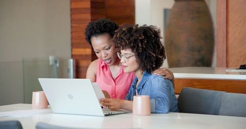 African American Women Collaborating on Laptop at Home