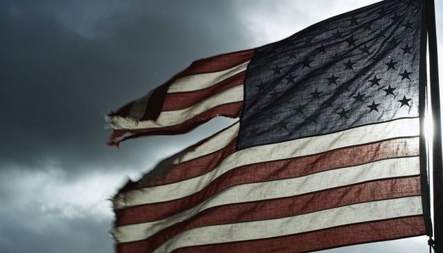 Fluttering tattered united states flag against stormy sky, weathered weave and frayed edges