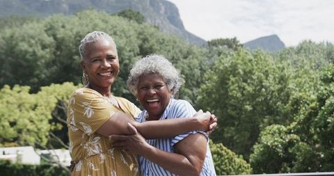 Senior Friends Embracing Joyfully in Scenic Outdoors