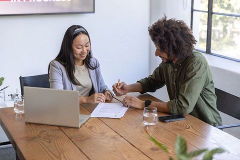 Co-workers Collaborating on Document in Office Environment