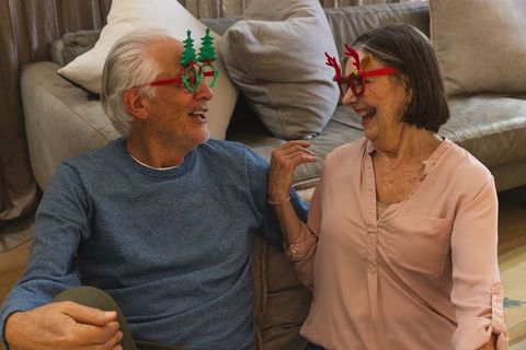 Senior couple sharing joy in festive holiday glasses at home