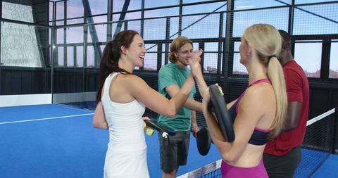 Diverse group of friends enjoying padel on indoor court