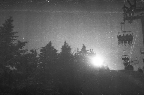 Vintage ski lift silhouetted against bright rising sun