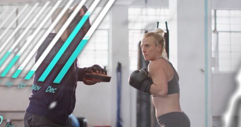 Female Boxer Throwing Jab Training with Coach Holding Mitts in Bright Gym