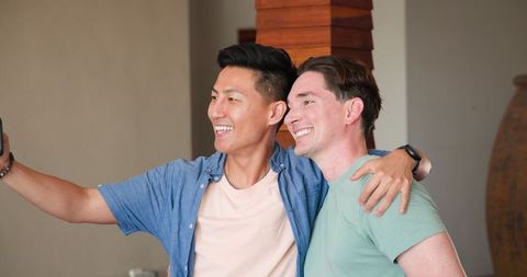 Joyful gay couple enjoying time together at home
