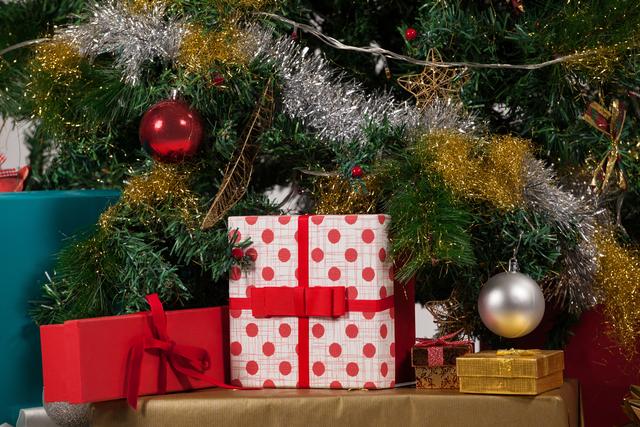 Perfect for holiday-themed promotions, greeting cards, and festive advertisements. Highlights the joy and tradition of Christmas gift-giving with beautifully wrapped presents under a decorated tree.