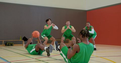 Basketball team performing core drill in indoor gym promoting teamwork and fitness training