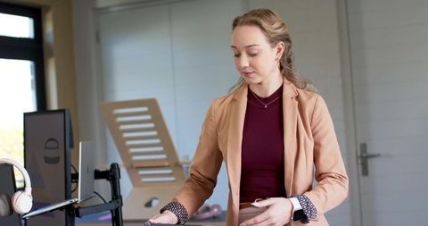 Female executive adjusting monitor arm in modern minimalist office workspace