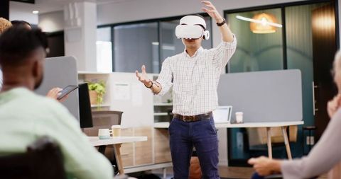 Man Demonstrating VR Technology to Colleagues in Modern Office