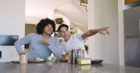 Two friends enjoying breakfast together in modern kitchen