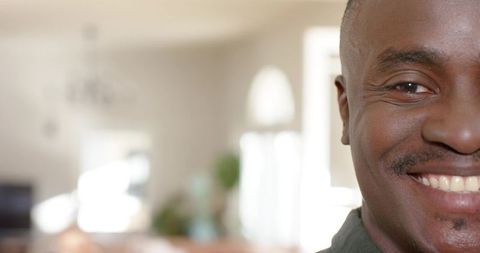 African american man smiling at home with natural light and arched windows, close headshot