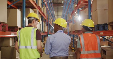 Diverse Warehouse Team Discussing Operations with Safety Gear - Download Free Stock Images Pikwizard.com