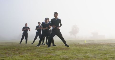 Team of Athletes Jogging Through Misty Field at Dawn
