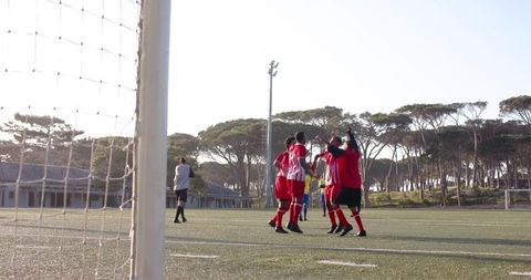 Soccer Players Huddling on Field Before Match Under Clear Sky