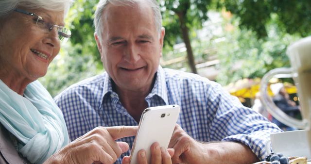 Senior Couple Using Smartphone Outdoors, Smiling - Download Free Stock Photos Pikwizard.com