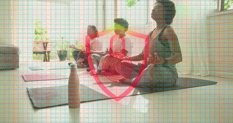 Group Meditating on Yoga Mats with Digital Wellness Shield Overlay in Sunlit Studio