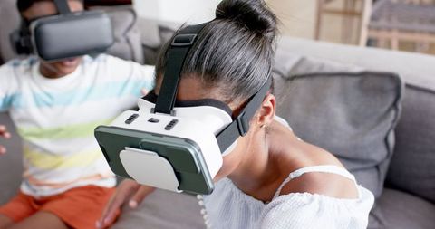Siblings Enjoying Virtual Reality Headsets on Couch