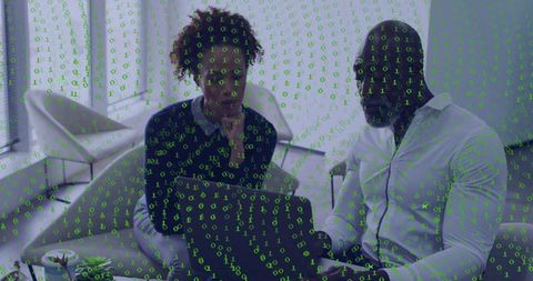 Colleagues discussing digital project on laptop with green binary overlay in modern lounge