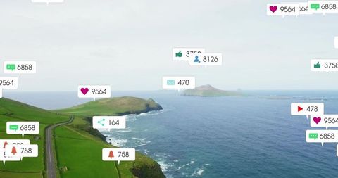 Coastal drone view showing winding road along emerald cliffs with social media badges