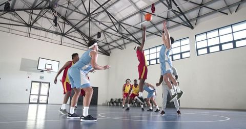 Diverse Male Athletes Competing in Indoor Basketball Game