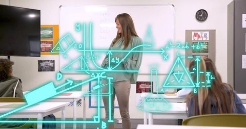Smiling female teacher teaching math with interactive digital diagrams to students in classroom