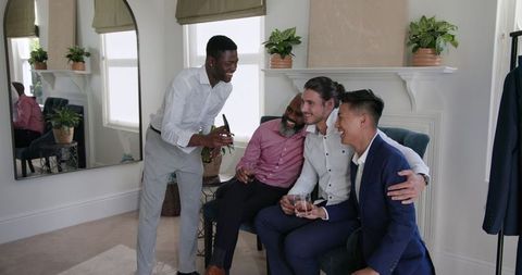 Friends Joyfully Socializing Indoors with Drinks