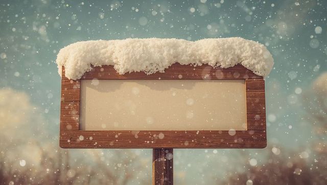 Wooden signboard covered in snow with falling snowflakes