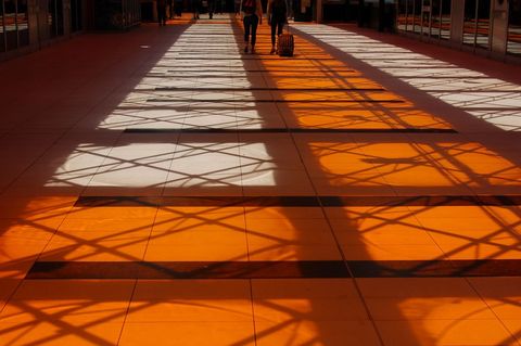 Silhouettes Walking Through Sunlit Building Interior