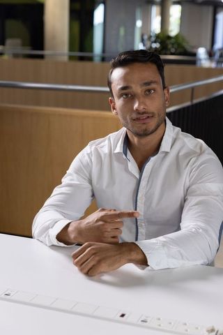 Professional man pointing to forearm in modern office setting