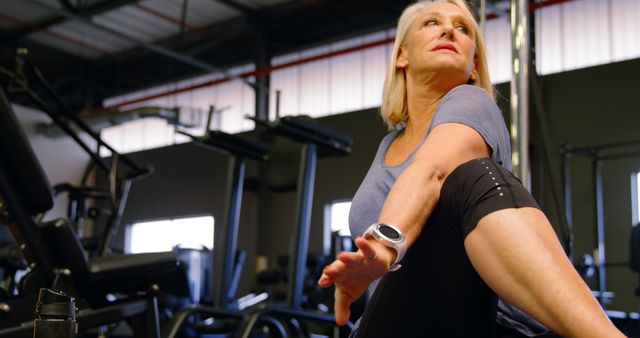 Senior Woman Stretching in Gym Setting with Fitness Gear - Download Free Stock Images Pikwizard.com