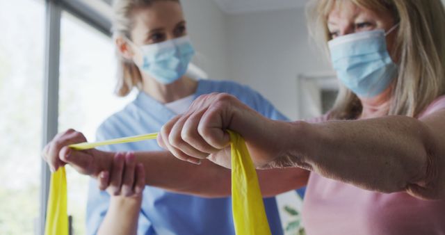 Physical Therapist Assisting Senior Woman with Resistance Band Exercises - Download Free Stock Images Pikwizard.com