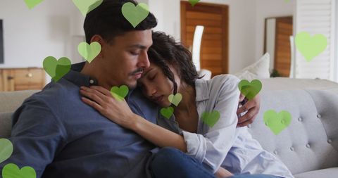Loving Couple Embracing on Couch with Heart Graphics