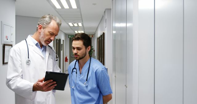 Experienced Doctor Mentoring Young Colleague in Hospital Corridor - Download Free Stock Images Pikwizard.com