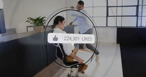 Playful coworkers sharing creative teamwork moment in bright open-plan office with likes overlay