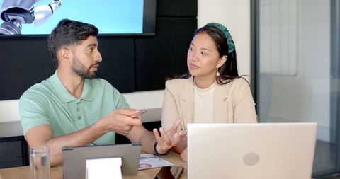 Diverse Colleagues Collaborating Over Technology in Modern Office