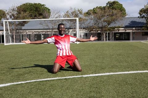 Cheerful soccer player celebrating victory on field