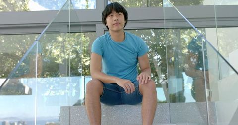 Asian Student Sitting on Stairs Thoughtfully in Blue Outfit