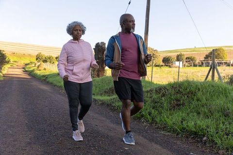Senior Couple Enjoying Brisk Walk on Countryside Road