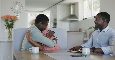Friends gathering at home laughing and reviewing documents