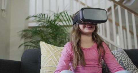 Young girl enjoying virtual reality experience at home