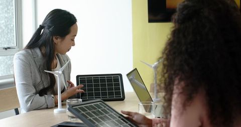 Female coworkers presenting renewable energy prototypes
