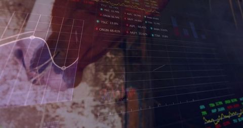 Financial dashboard overlay on desk showing line graphs and stock tickers, analyst in maroon