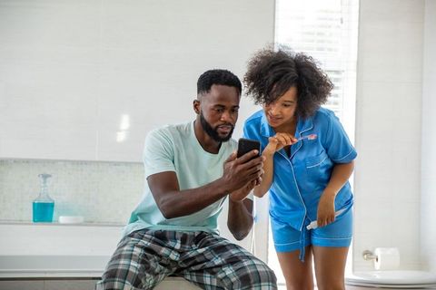 Couple in Pajamas Engaged with Smartphone in Bathroom