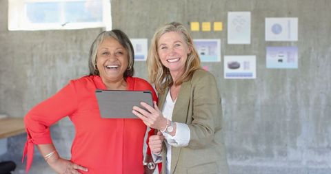 Diverse Female Coworkers Collaborating on Tablet in Modern Office