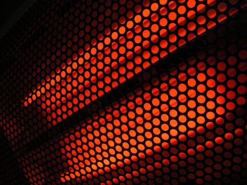 Glowing red perforated metal panel with diagonal light pattern