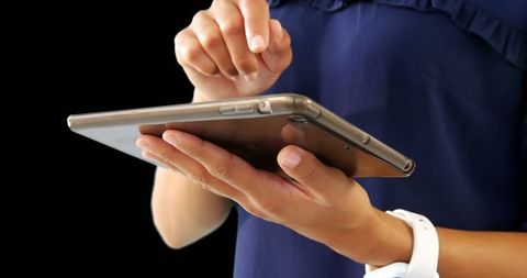 Businesswoman Using Digital Tablet Against Dark Background