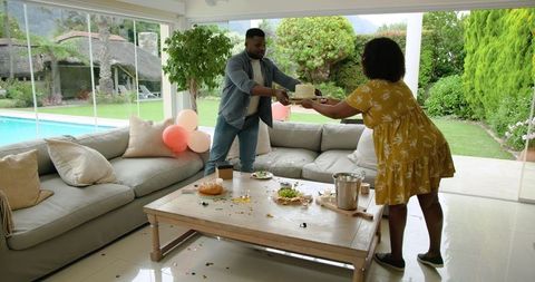 Happy couple celebrating with birthday cake at home gathering