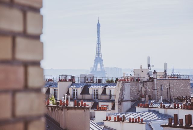 Roofscape View of Eiffel Tower through City Buildings on a Misty Morning - Download Free Stock Images Pikwizard.com