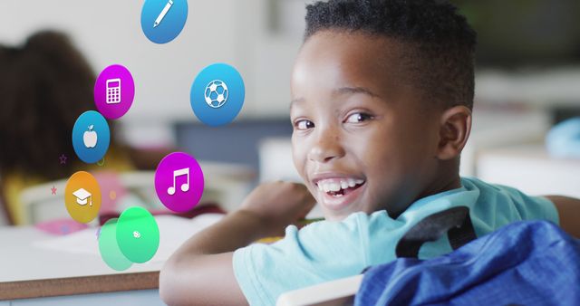 African American boy sitting in a classroom, smiling with educational icons displayed around him representing various subjects like music, sports, and academics. This can be used for promoting education, technology in classrooms, or highlighting diversity in learning environments.