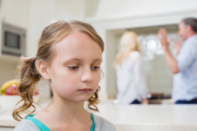 Young girl looking sad and distressed while her parents argue in the background. Useful for illustrating family conflict, emotional stress in children, and the impact of domestic issues on young ones. Ideal for articles, blogs, or campaigns related to family therapy, child psychology, and divorce.